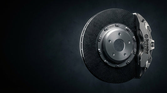 A close-up of a high-performance carbon ceramic brake rotor and caliper assembly showcasing the textured composite material.