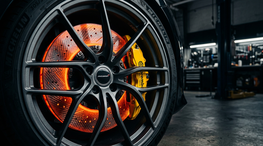 Close-up of a high-performance carbon ceramic brake rotor and yellow caliper on a luxury hypercar, representing CCB and CCM replacement solutions for Ferrari, McLaren, and Lamborghini.