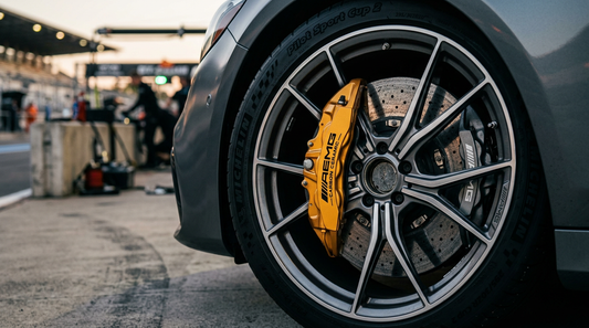 Close-up of a high-performance carbon ceramic brake rotor and gold caliper on a luxury sport sedan wheel.