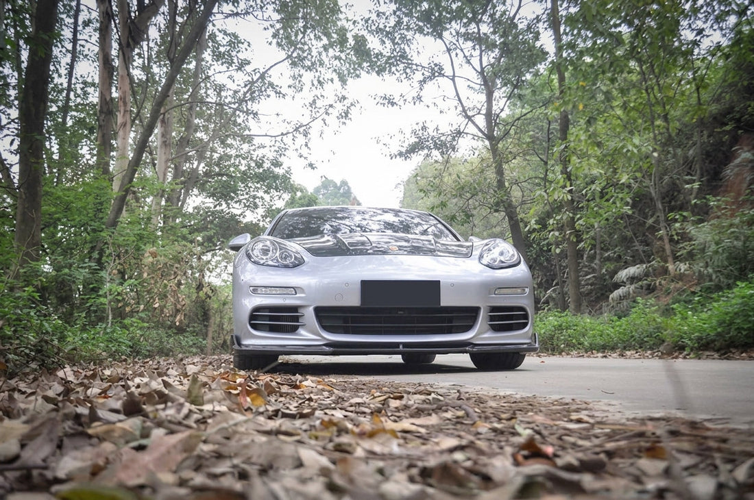 CMST carbon fibre aero kit on Porsche Panamera in black, 3/4 front low angle studio garage lighting