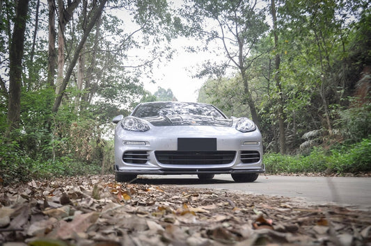 CMST carbon fibre aero kit on Porsche Panamera in black, 3/4 front low angle studio garage lighting
