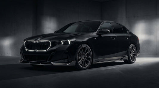 Black BMW 5 Series G60 with CMST carbon front lip and rear lip, low front three-quarter studio shot