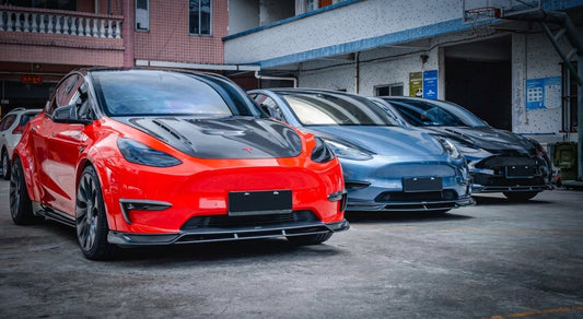 Tesla Model Y in gloss red wearing a CMST carbon fibre widebody body kit with raised rear wing and carbon diffuser