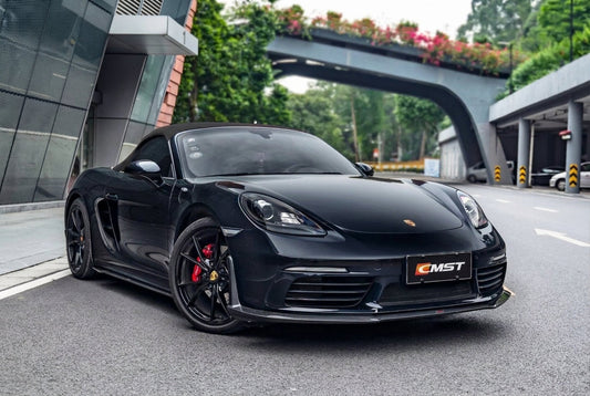 CMST carbon fibre aero kit on Porsche 718 Cayman in Guards Red, 3/4 front low angle studio lighting showing carbon lip, skirts and rear wing