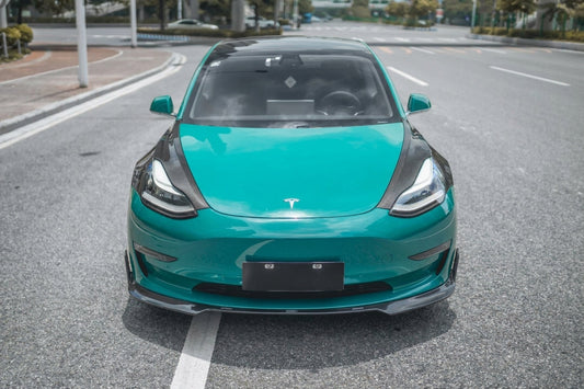 Pre-facelift Tesla Model 3 in teal wearing the CMST carbon-fibre aero kit, 3/4 front low angle