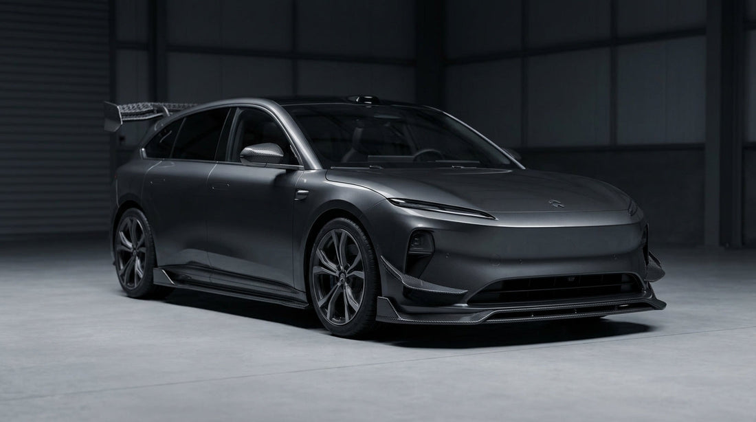 NIO ET5T shooting brake in dark grey with CMST carbon fibre aero kit, 3/4 front low angle in moody garage lighting