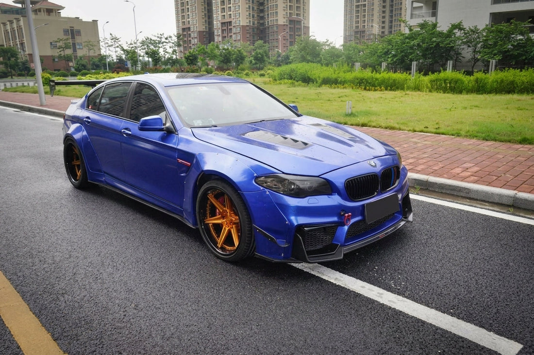 BMW F10 5 Series in metallic blue on CMST 20-inch two-piece forged wheels with bronze faces, front three-quarter low angle
