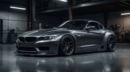 BMW Z4 E89 roadster with a wide-body kit and flared fenders, low front three-quarter hero in a moody garage