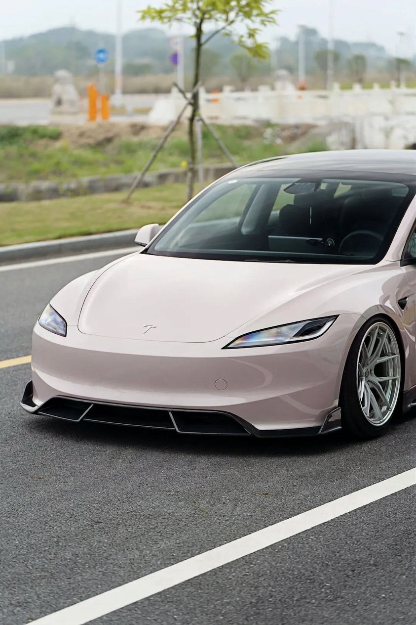 2024 Tesla Model 3 Highland in pearl white wearing the CMST carbon-fibre aero kit, 3/4 front low angle