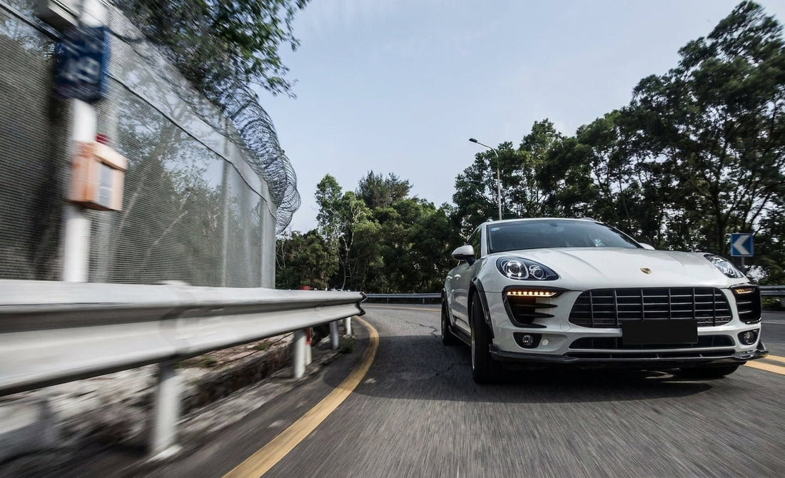 White Porsche Macan widebody with CMST carbon front lip, fenders and wing on bronze 21-inch forged wheels, low front three-quarter hero