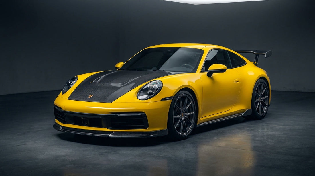 Yellow Porsche 911 992 Carrera with CMST carbon front lip, vented bonnet and rear wing in a studio