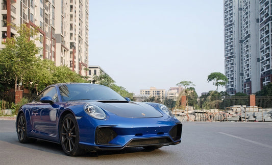 Blue Porsche 911 (991) with CMST carbon front bumper, bonnet and three-piece rear wing, low front three-quarter hero