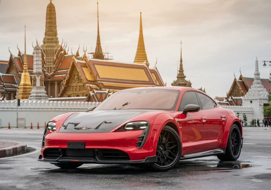 Red Porsche Taycan with CMST carbon bonnet, front lip and rear spoiler on black forged wheels, low front three-quarter hero