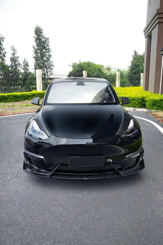 Tesla Model Y in gloss black wearing the CMST dry-carbon aero kit, 3/4 front low angle
