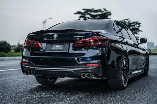 BMW 5 Series G38 M550i in black sapphire with CMST carbon front lip and side skirts, low front three-quarter hero