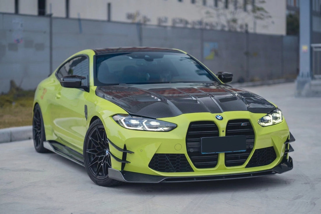 Sao Paulo Yellow BMW M4 Competition G82 wearing the full CMST dry-carbon aero kit, front three-quarter low angle with visible carbon-fibre weave