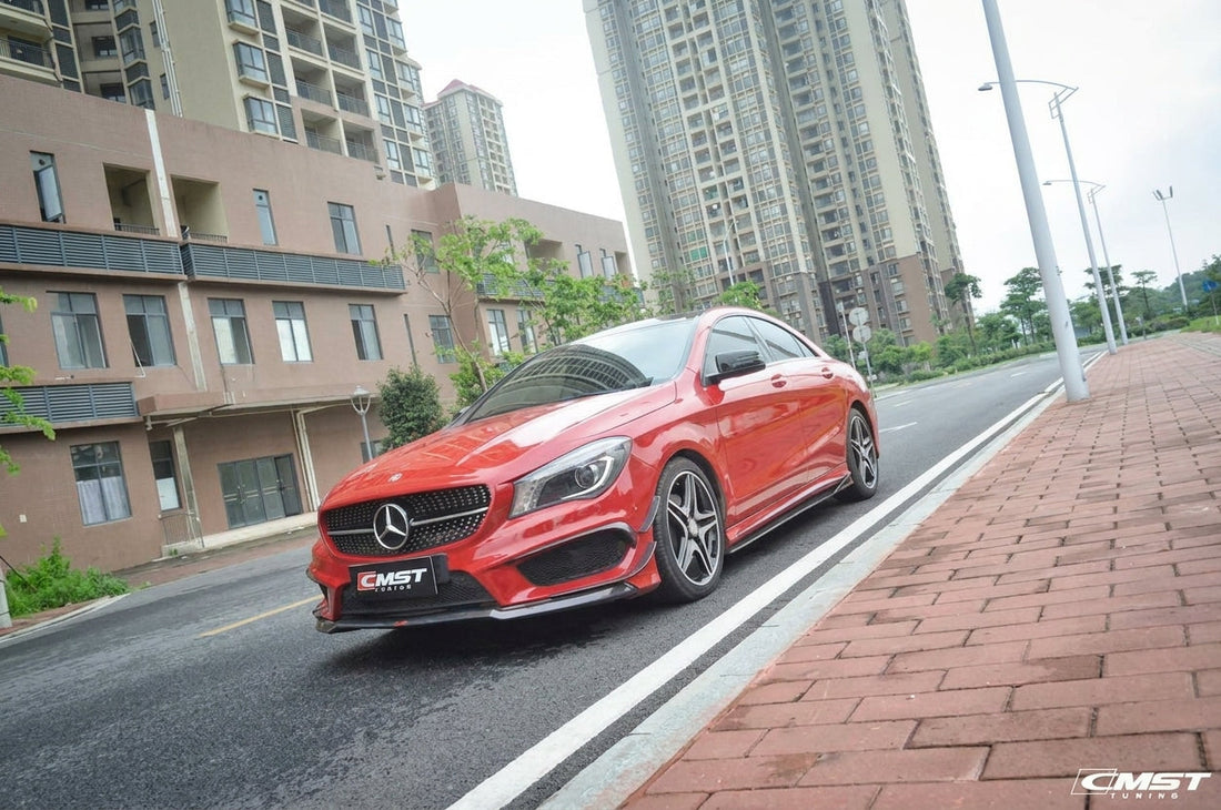 Red Mercedes-Benz CLA wearing a CMST carbon fibre small kit with front lip and canards, front three-quarter low angle in a studio