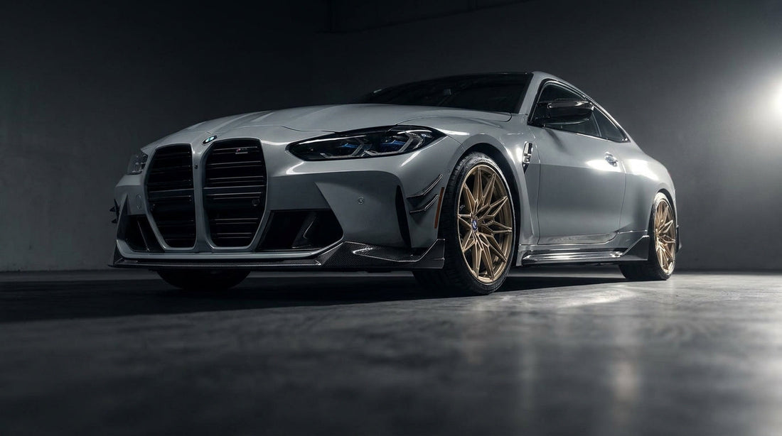 Grey BMW M4 G82 with CMST carbon front lip, canards and side skirts, low front three-quarter studio shot