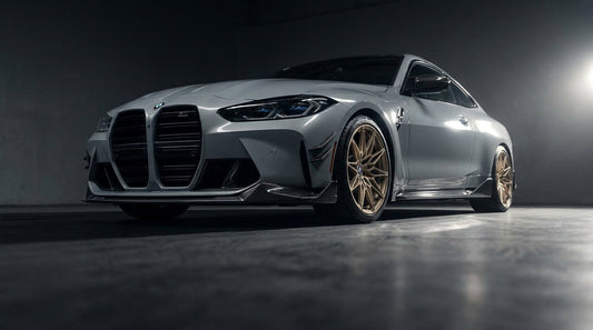 Grey BMW M4 G82 with CMST carbon front lip, canards and side skirts, low front three-quarter studio shot
