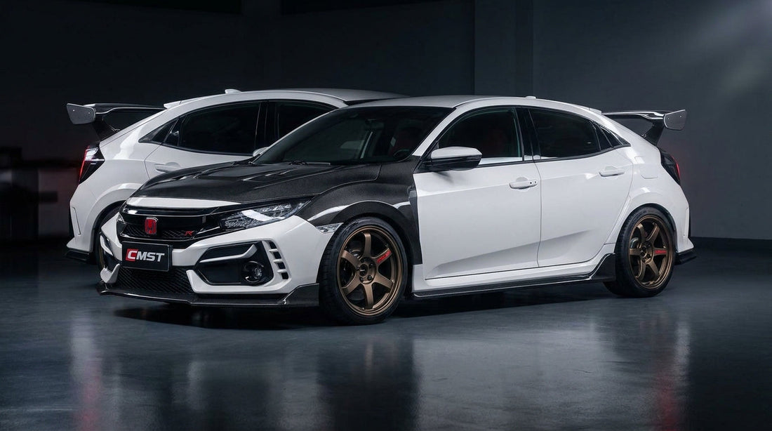White Honda Civic FK7 hatch wearing the CMST carbon-fibre widebody kit with Type R-style rear wing, front three-quarter low angle