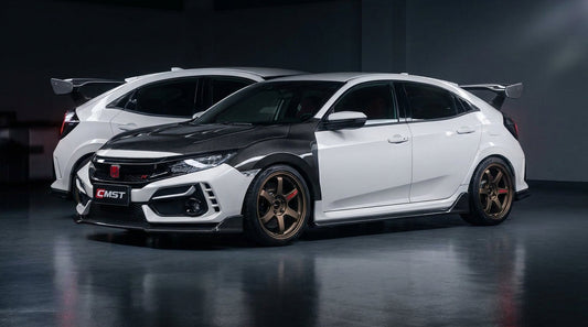 White Honda Civic FK7 hatch wearing the CMST carbon-fibre widebody kit with Type R-style rear wing, front three-quarter low angle