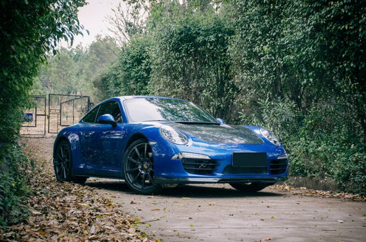 CMST carbon fibre aero kit on Porsche 911 992 in Jet Black, 3/4 front low angle studio garage lighting showing vented carbon bonnet and front lip