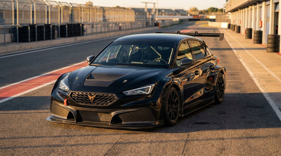 CMST carbon fibre aero kit on a modified touring car at a racing circuit, low angle front view showing carbon splitter and diffuser details