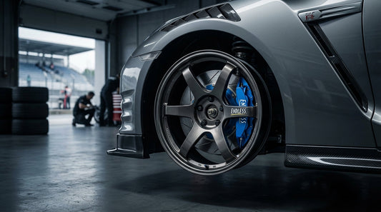 Close-up of a Nissan GT-R R35 high-performance brake system featuring blue Endless calipers and slotted rotors for track use.