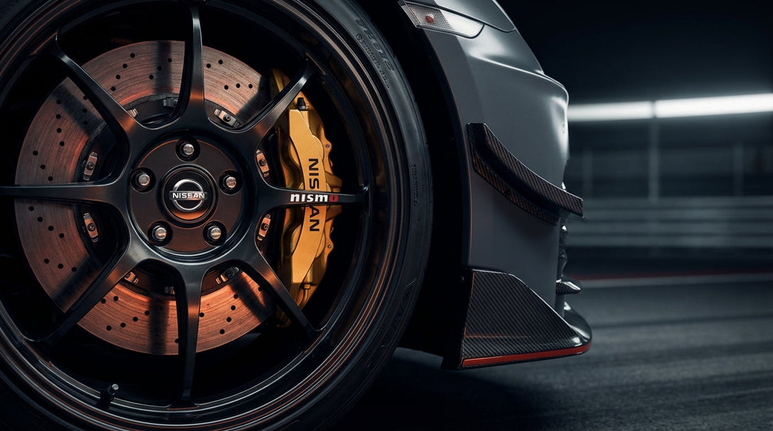 Close-up of a high-performance carbon ceramic brake rotor and gold caliper on a Nissan GT-R R35 NISMO Track Edition.