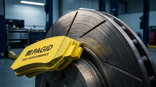 Close-up of Pagid yellow performance brake pads installed on a ventilated disc rotor for a performance automotive buyer's guide.
