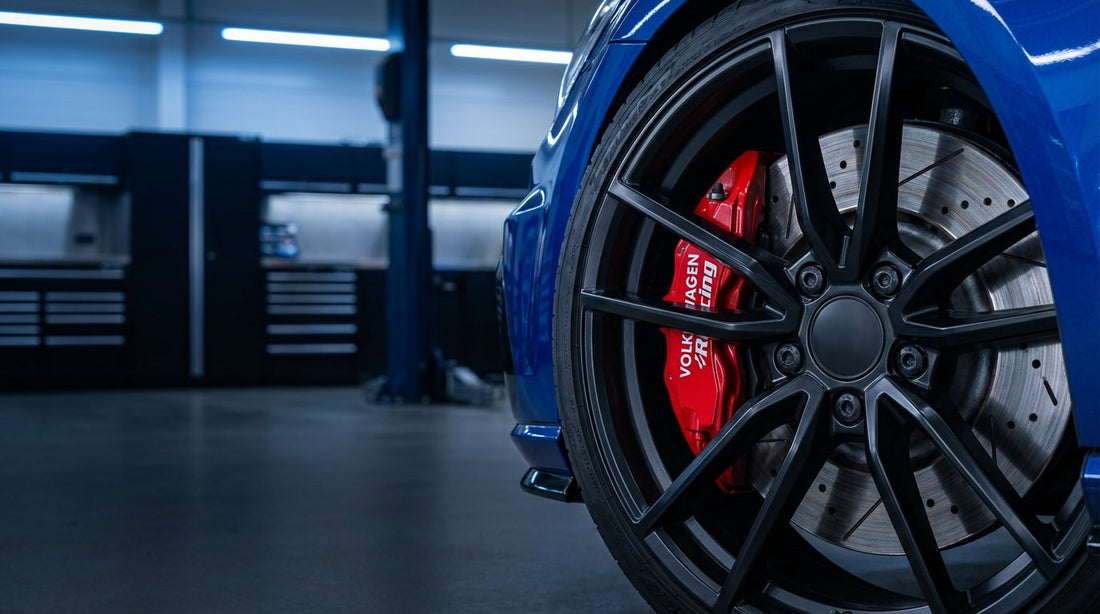 Close-up of a high-performance big brake kit with a red multi-piston caliper and slotted rotor on a Volkswagen Golf R.
